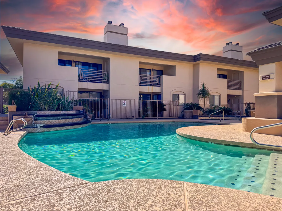 This image showcases a sparkling swimming pool surrounded by manicured landscaping and the building's facade, inviting guests to swim, sunbathe, or socialize in a relaxed setting.